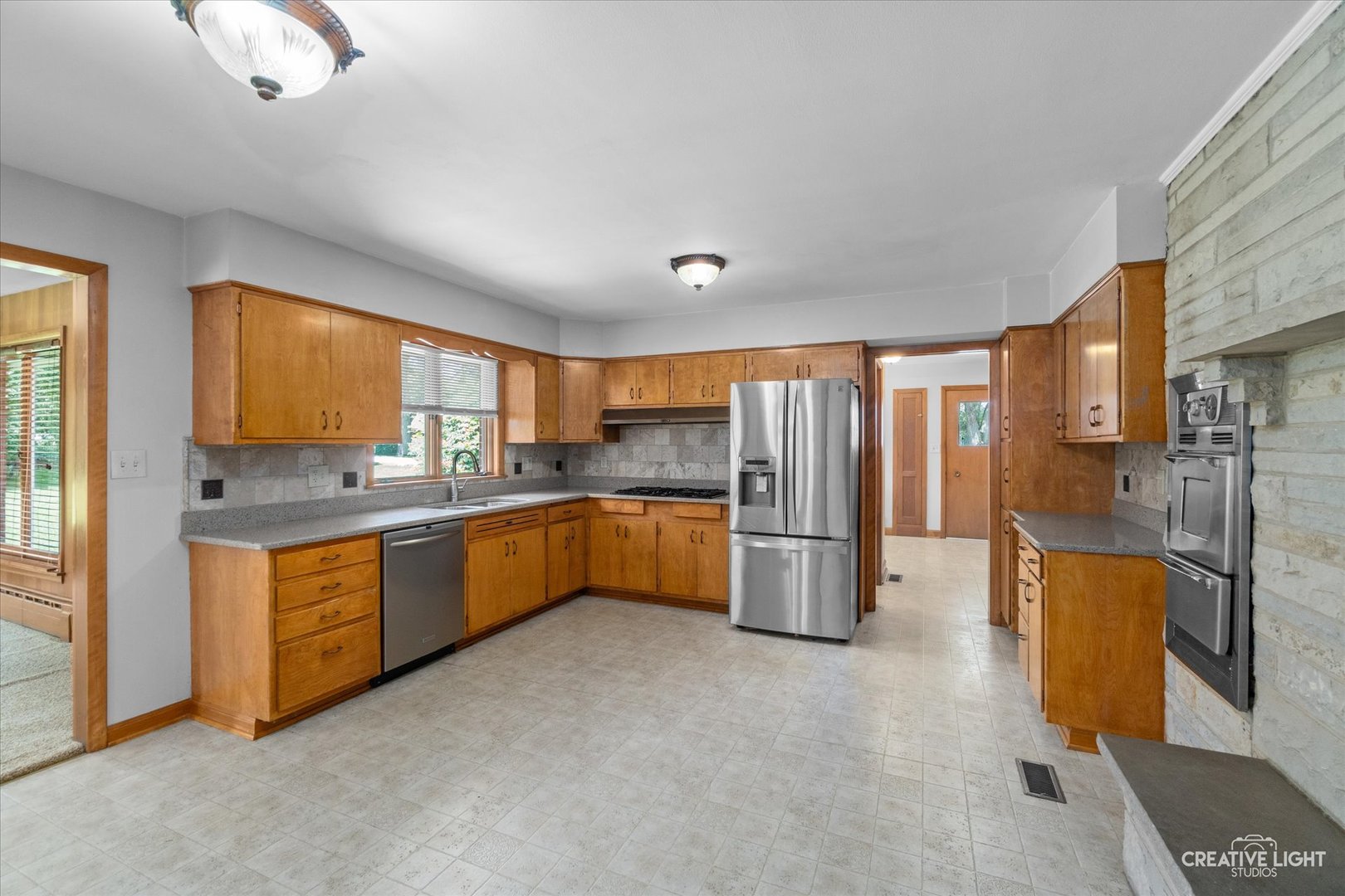 1402 Meadows Road Geneva, IL 60134 - Photo 9 of 30 a kitchen with stainless steel appliances granite countertop a refrigerator a stove and a sink with cabinets