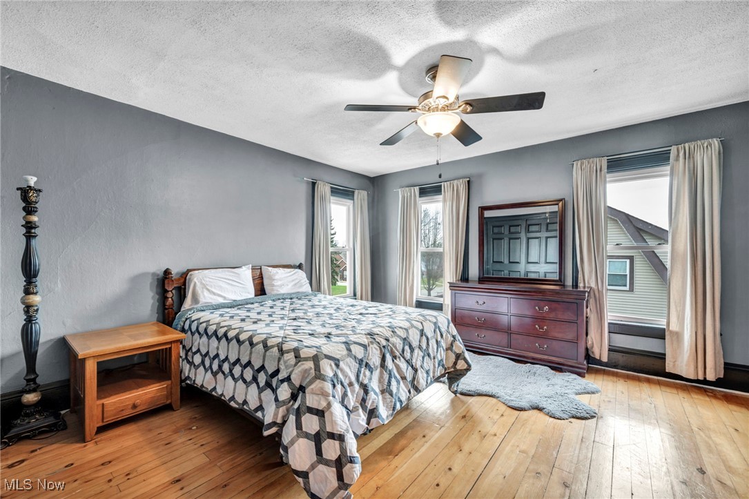 4743 Broadale Road Cleveland, OH 44109 - Photo 17 of 32 Bedroom with a textured ceiling, light wood-style floors, and ceiling fan