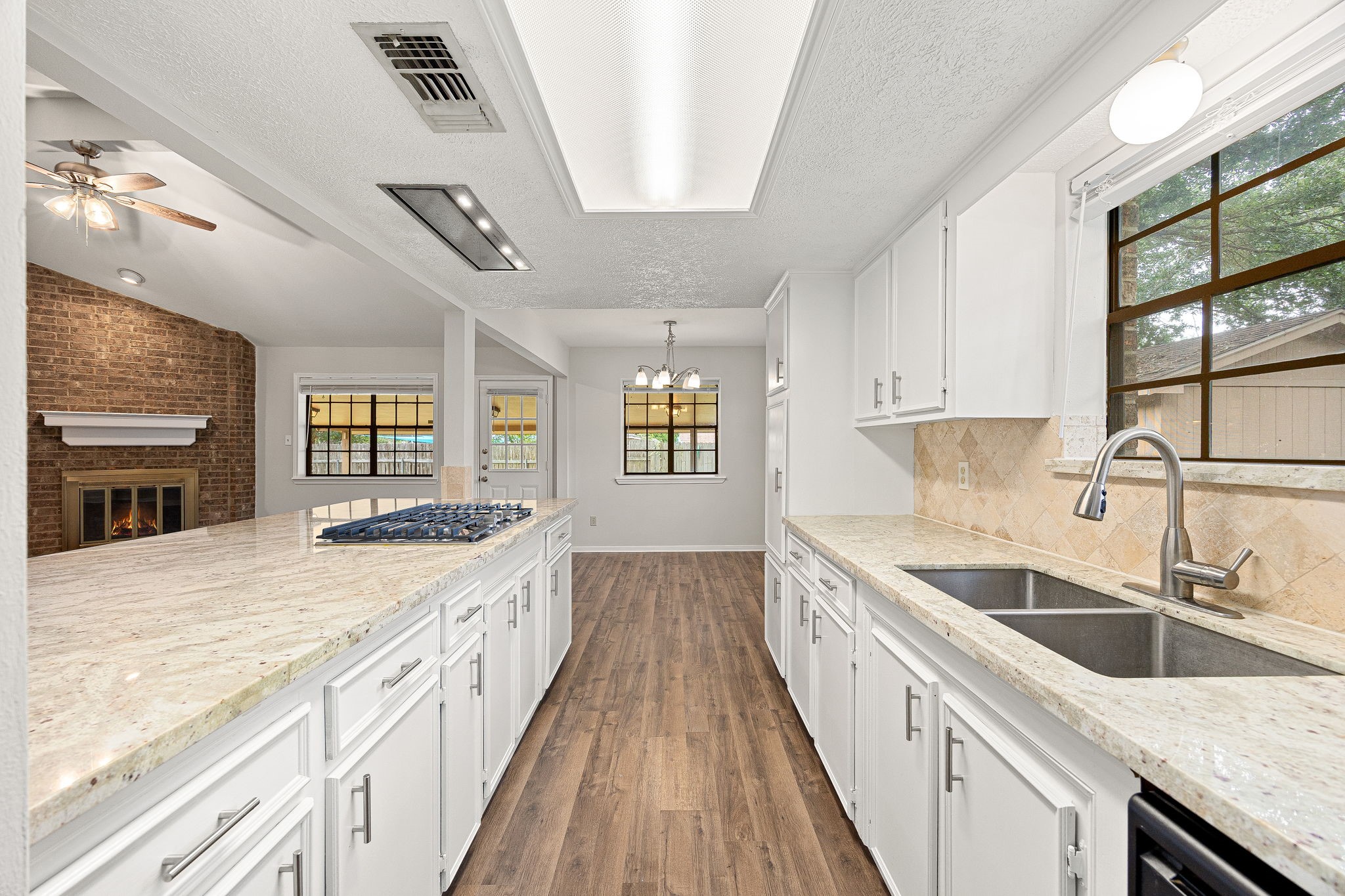 2019 Franklin Circle Rosenberg, TX 77471 - Photo 6 of 19 A gas cooktop with overhead vent sits along the breakfast bar, opening directly to the living area's fireplace—keeping the cook connected to family and guests.
