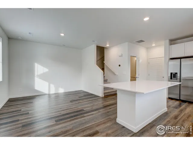 a kitchen with kitchen island a counter top space cabinets and a refrigerator