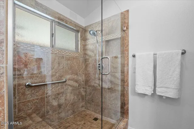 a bathroom with a shower and a glass door