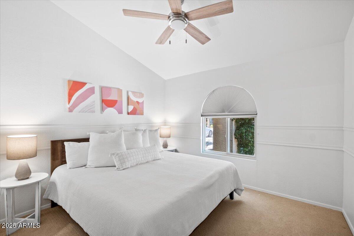 9081 East Sahuaro Drive Scottsdale, AZ 85260 - Photo 19 of 22 a bedroom with a large bed and a chandelier