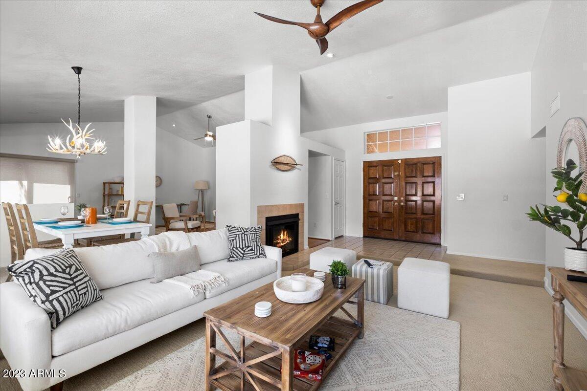 9081 East Sahuaro Drive Scottsdale, AZ 85260 - Photo 5 of 22 a living room with furniture a fireplace and a chandelier