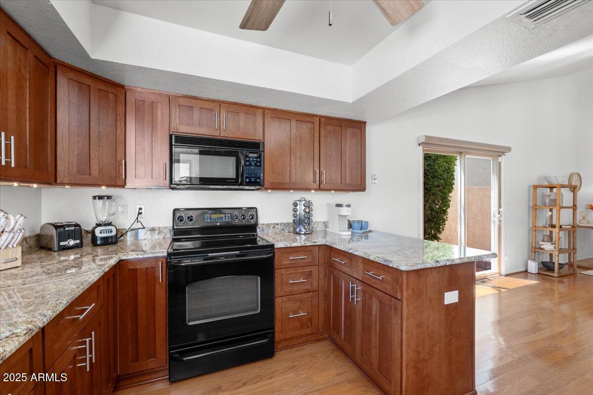 9081 East Sahuaro Drive Scottsdale, AZ 85260 - Photo 10 of 22 a kitchen with stainless steel appliances granite countertop a stove a sink and a microwave