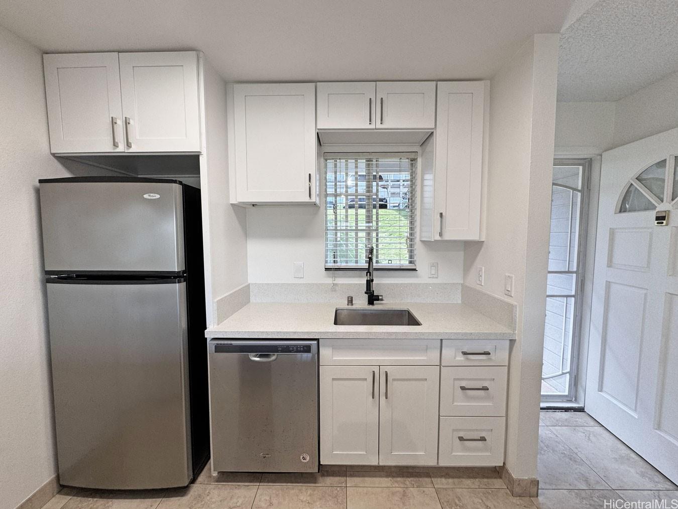 92-1150 Hame Street, Unit 8102 Kapolei, HI 96707 - Photo 11 of 19 a kitchen with stainless steel appliances a sink cabinets and a window