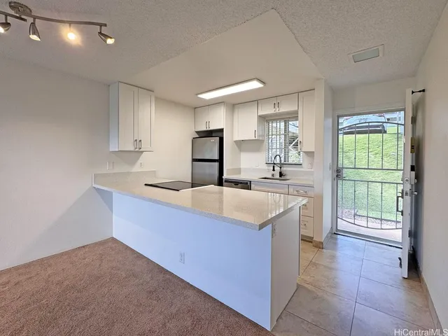 a kitchen with stainless steel appliances granite countertop a sink a stove and a refrigerator