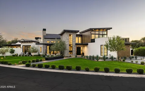a front view of a house with a yard and potted plants