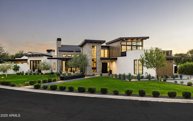 a front view of a house with a yard and potted plants