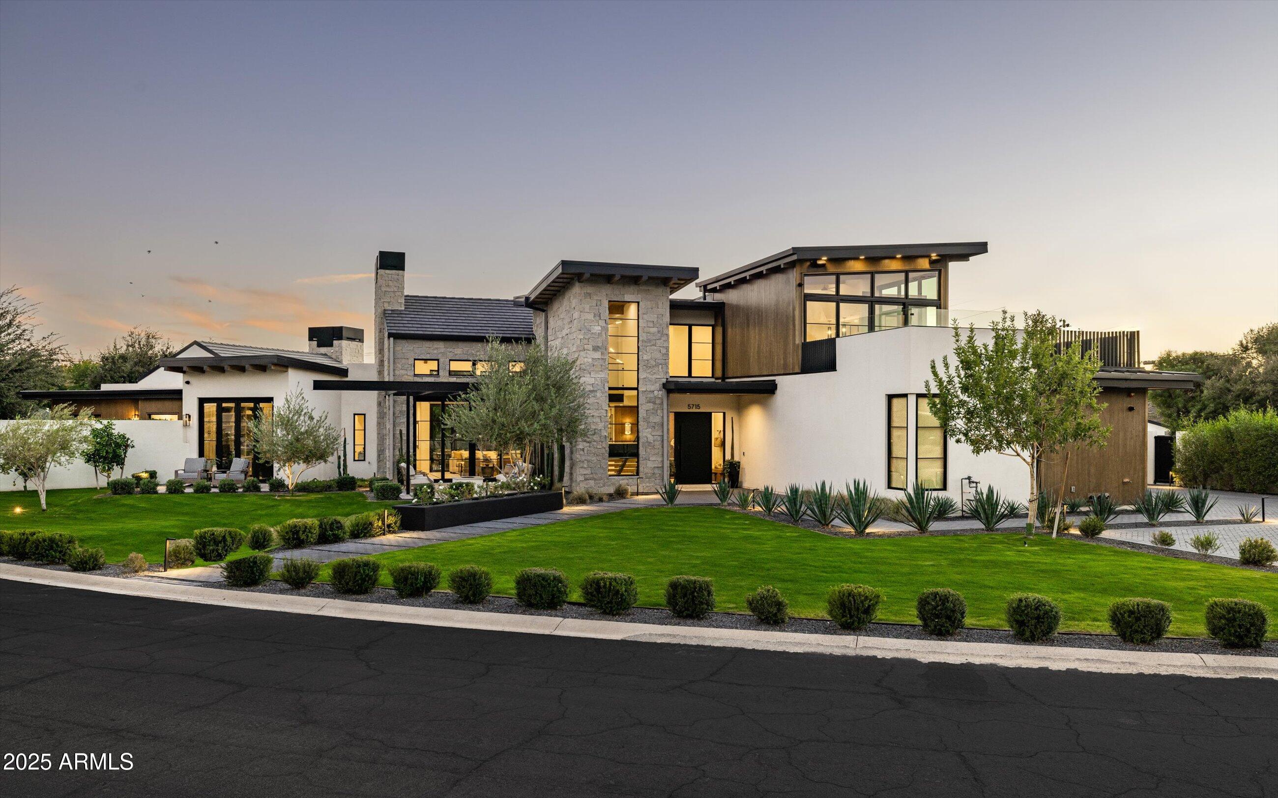 a front view of a house with a yard and potted plants