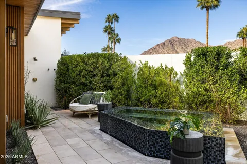 a view of a patio with table and chairs potted plants with floor to ceiling window