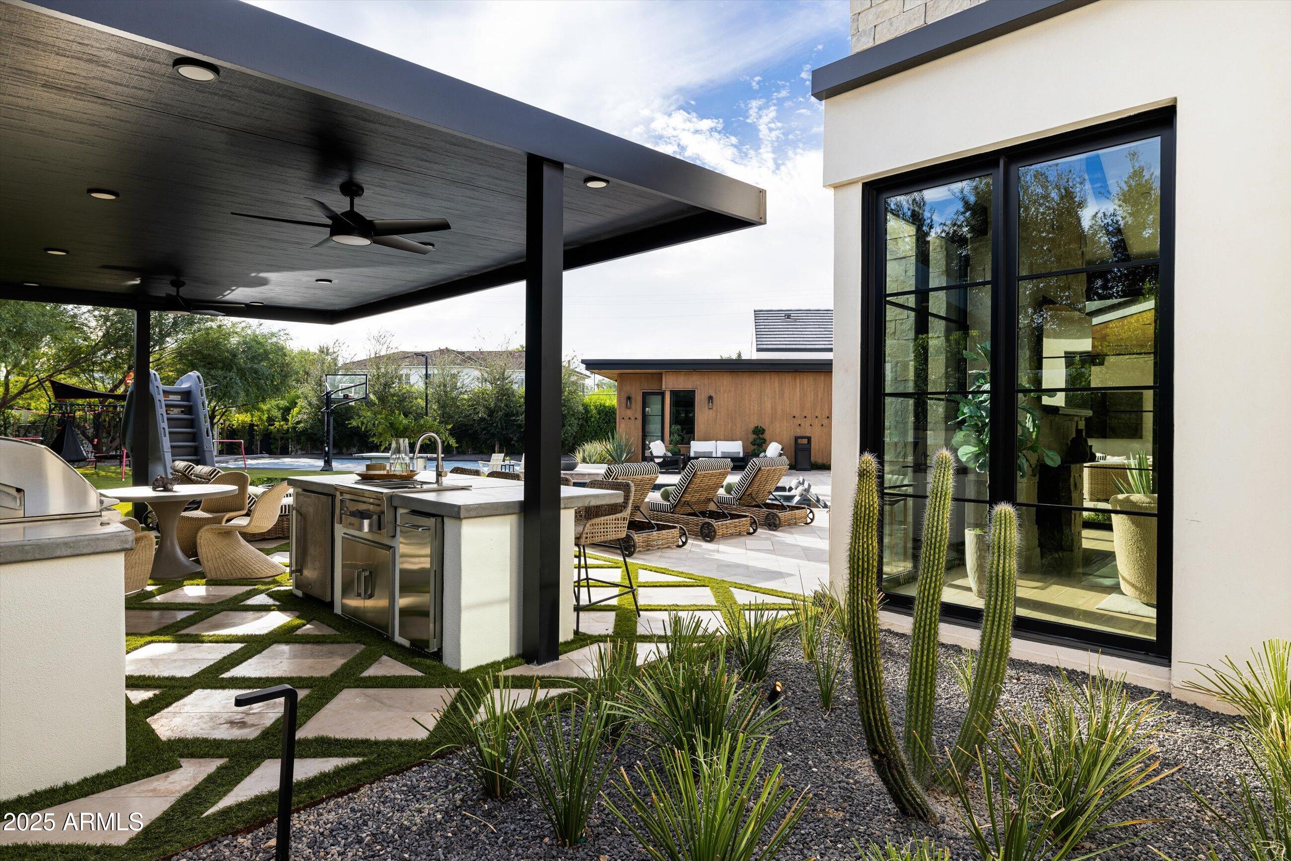 5715 East Monterosa Street Phoenix, AZ 85018 - Photo 52 of 113 a view of a patio with table and chairs potted plants with floor to ceiling window