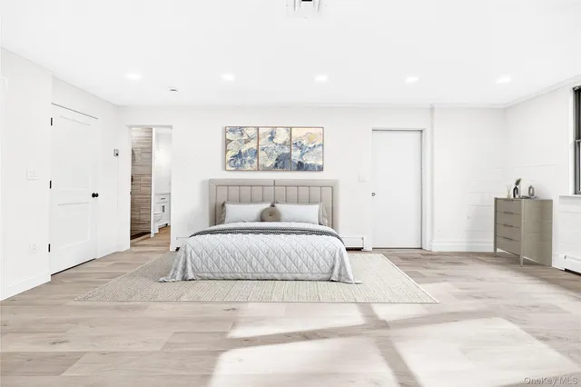 a spacious bedroom with a bed and a painting on the wall