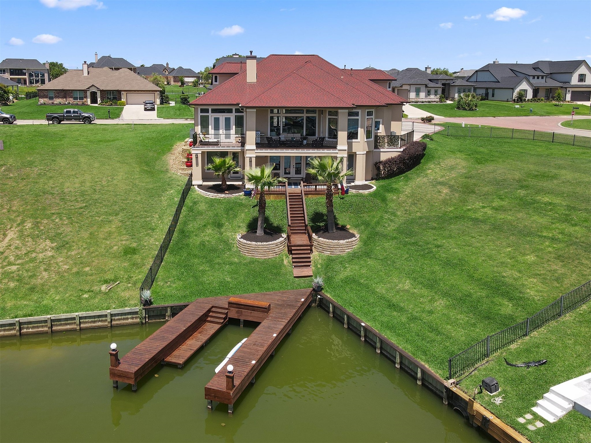 10896 Decatur Street Willis, TX 77318 - Photo 6 of 50 Experience luxury waterfront living in this modern home with a striking red gabled roof, nestled on a spacious, landscaped lot, featuring a private dock and convenient staircase from the back porch for seamless boating and relaxation.