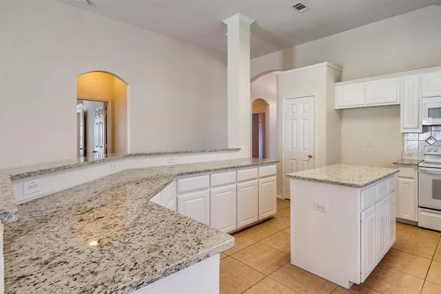 a bathroom with a granite countertop sink a mirror and a bathtub