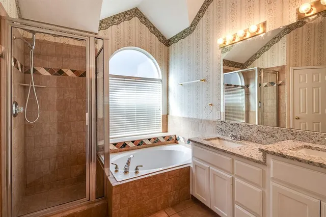 a bathroom with a granite countertop sink a mirror and a shower