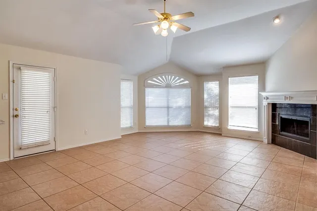 a view of an empty room with a window and a kitchen