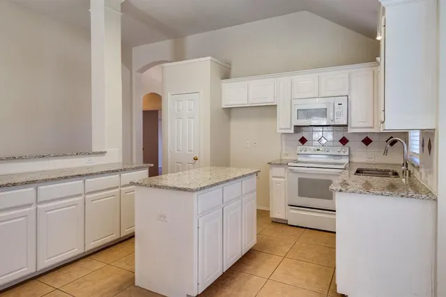 a kitchen with a sink stove and cabinets