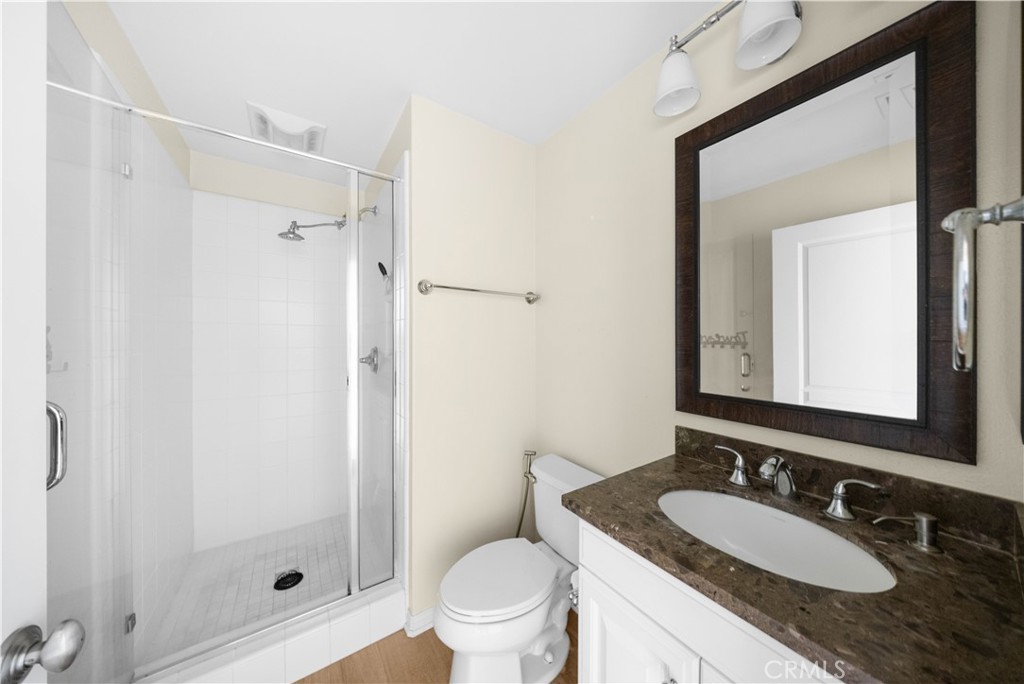 24 Lacebark, Unit 48 Irvine, CA 92618 - Photo 12 of 21 a bathroom with a granite countertop sink toilet a mirror a vanity and shower