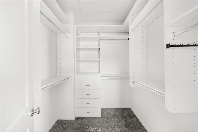 a view of walk in closet with empty racks