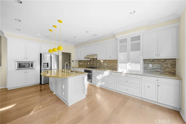 a kitchen with stainless steel appliances a refrigerator and a stove top oven