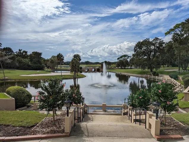 a view of swimming pool with outdoor seating and lake view