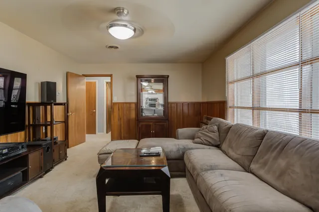 a living room with furniture a window and a flat screen tv