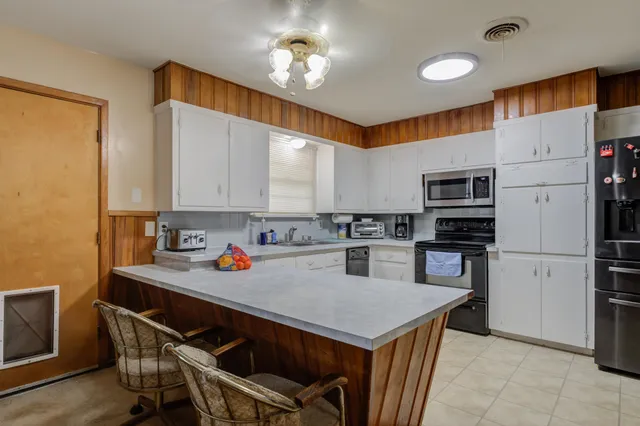 a kitchen with a refrigerator a stove a sink and a microwave