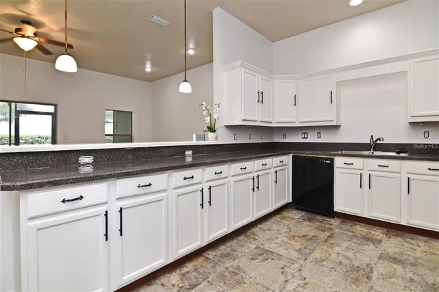 a kitchen with granite countertop white cabinets white appliances and sink