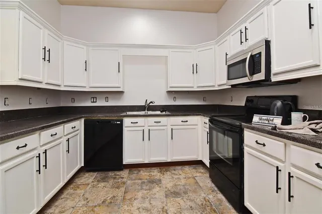 a kitchen with stainless steel appliances granite countertop a sink and a stove