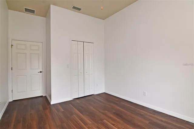 a view of an empty room with wooden floor