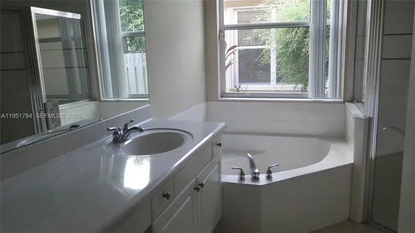 a bathroom with a tub sink and mirror