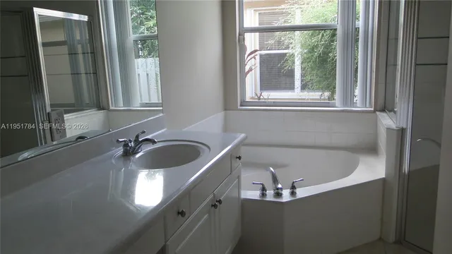 a bathroom with a tub sink and mirror