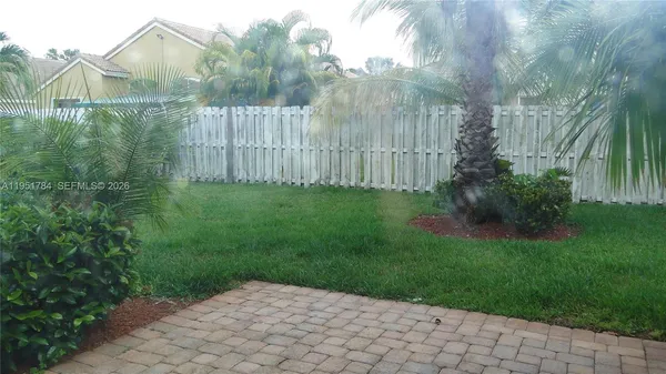 a view of backyard with potted plants and wooden fence