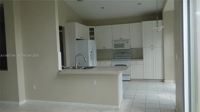 a kitchen with stainless steel appliances granite countertop a sink a stove a refrigerator and cabinets