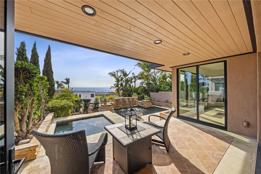 5381 Moonlight Lane La Jolla, CA 92037 - Photo 12 of 44 a view of a patio with table and chairs potted plants with wooden floor
