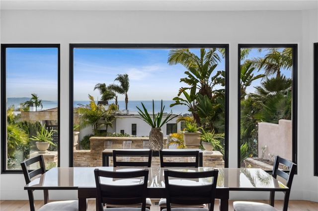 a view of a dining room with furniture one side kitchen view and wooden floor