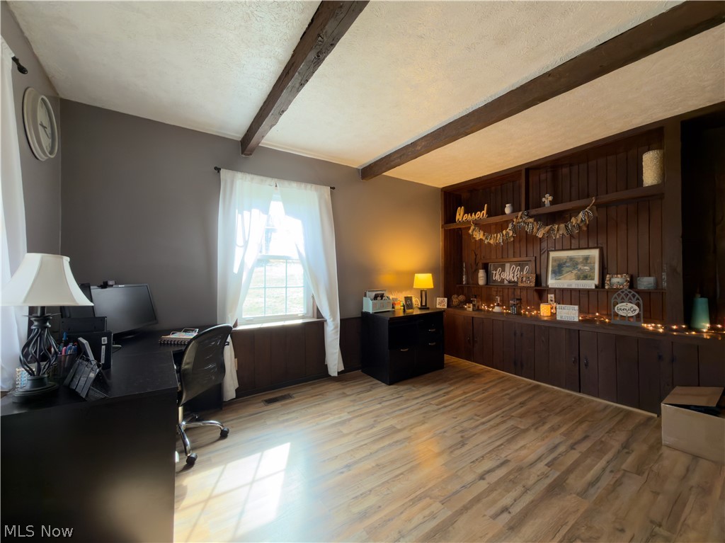 17377 Murphy Road Amesville, OH 45711 - Photo 17 of 43 Home office featuring wooden walls, light wood finished floors, beamed ceiling, and a textured ceiling
