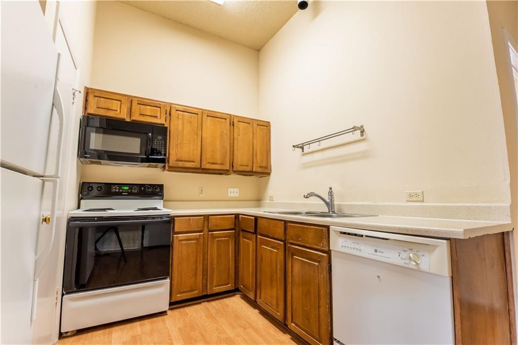 2216 San Gabriel Street, Unit 206 Austin, TX 78705 - Photo 4 of 11 a kitchen with a sink stove and microwave