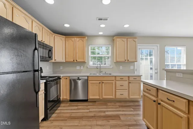 a view of kitchen with wooden floor and electronic appliances