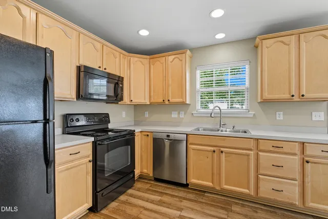 a kitchen with granite countertop a refrigerator stove and sink