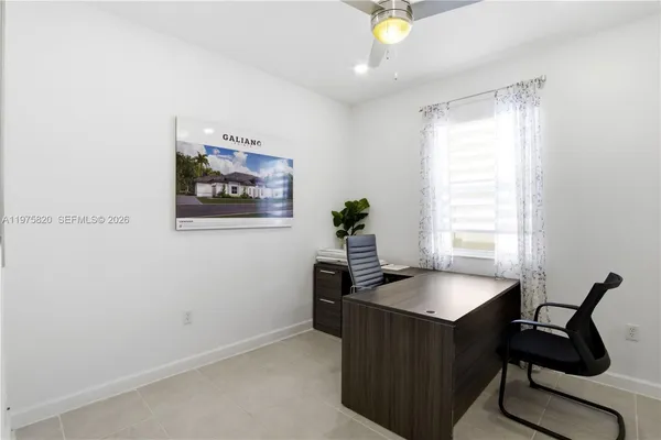 a view of a workspace with furniture and a window