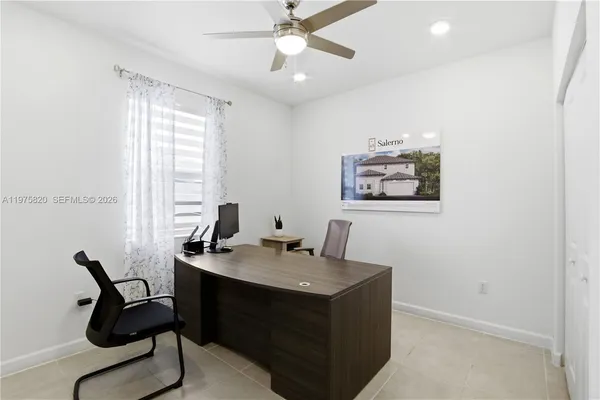 a view of a workspace with furniture and a window