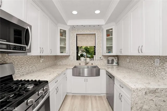 a kitchen with cabinets stainless steel appliances and sink