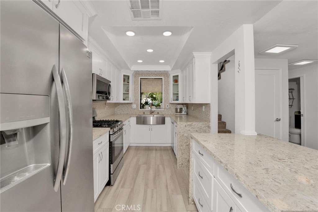 646 Sycamore Avenue, Unit 18 Claremont, CA 91711 - Photo 23 of 46 a large kitchen with stainless steel appliances kitchen island granite countertop a large counter top a sink a stove and a refrigerator