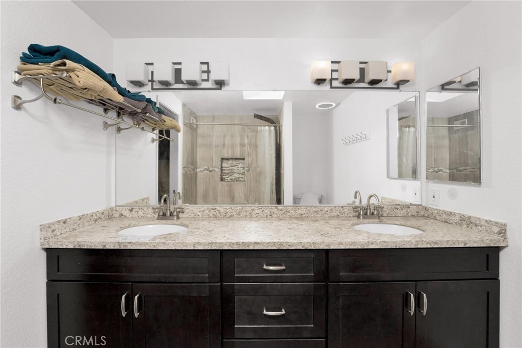 646 Sycamore Avenue, Unit 18 Claremont, CA 91711 - Photo 36 of 46 a bathroom with a granite countertop sink a large mirror and vanity