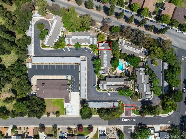 an aerial view of residential houses with outdoor space and trees