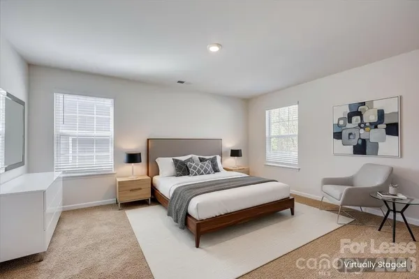 a bedroom with a large bed a couch and dresser