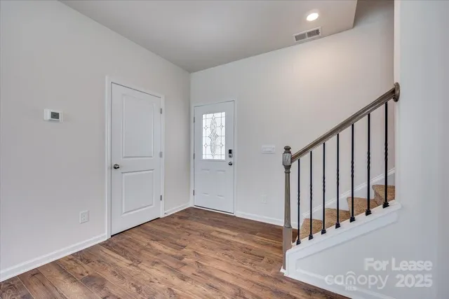 a view of a hallway with wooden floor and entryway