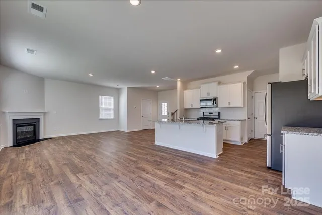 a large kitchen with stainless steel appliances kitchen island a large counter top and a stove top oven