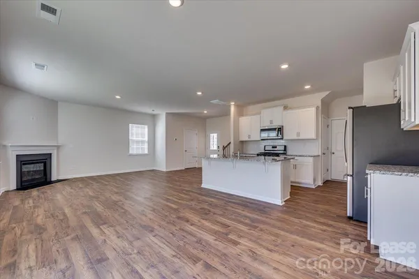 a large kitchen with stainless steel appliances kitchen island a large counter top and a stove top oven